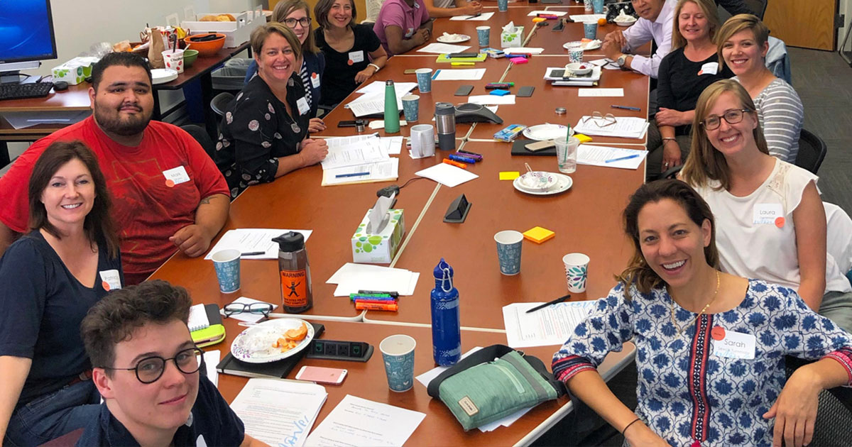 Move Minnesota board and staff smile together around a large conference table during a group retreat.