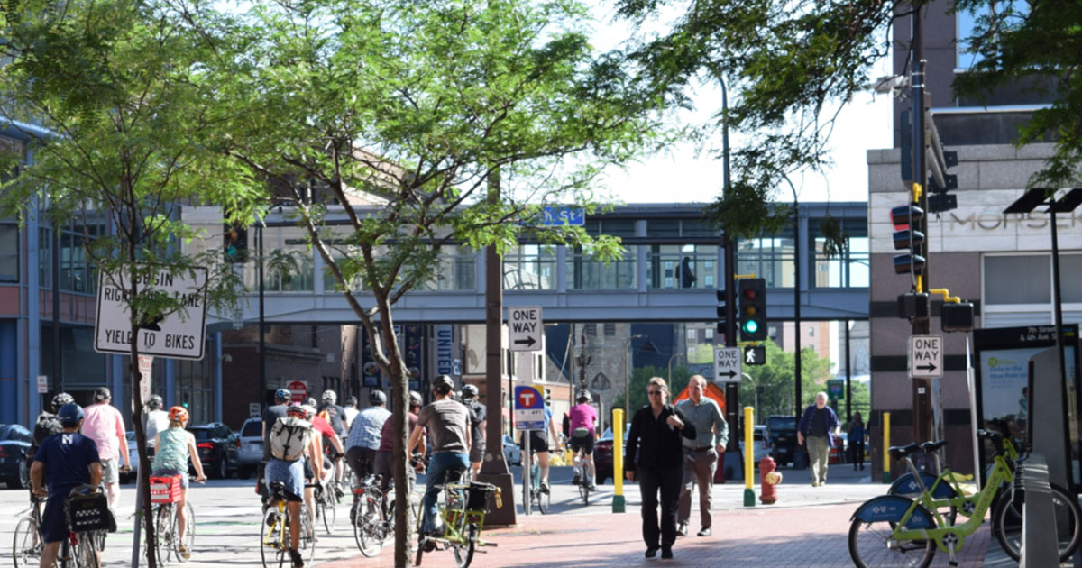 A large group of people walking and biking in downtown Minneapolis.