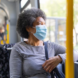 Woman wearing a face mask on the bus