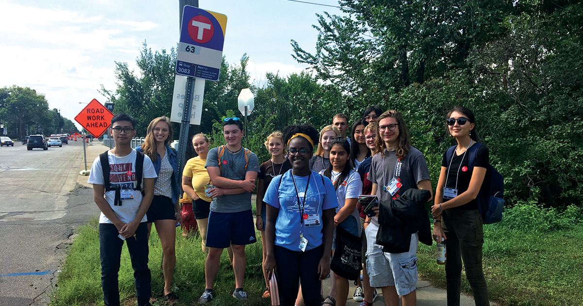 A group of students at a Metro Transit bus stop.