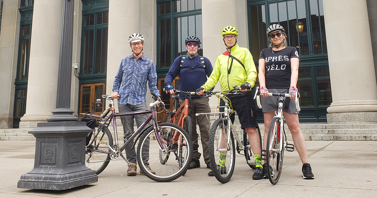 A group stands outside of the Saint Paul Union Depot with their bicycles on a Move Minnesota group ride.