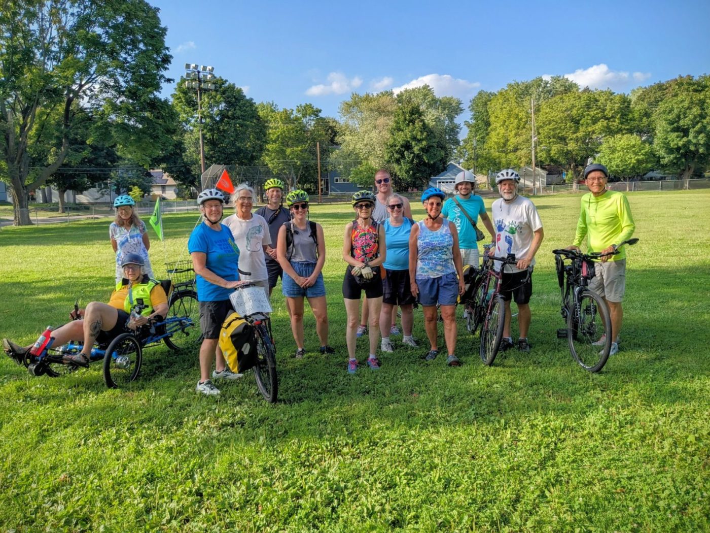 A group of people on a Move Minnesota bike ride gather with their bikes at a park in Saint Paul.