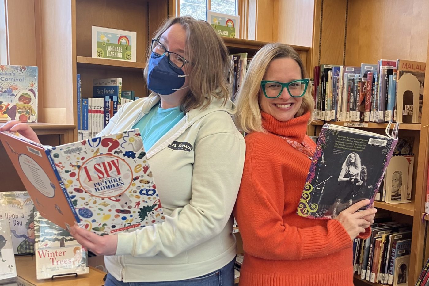 Photo of a Move Minnesota staff posing back to back with a smiling librarian 