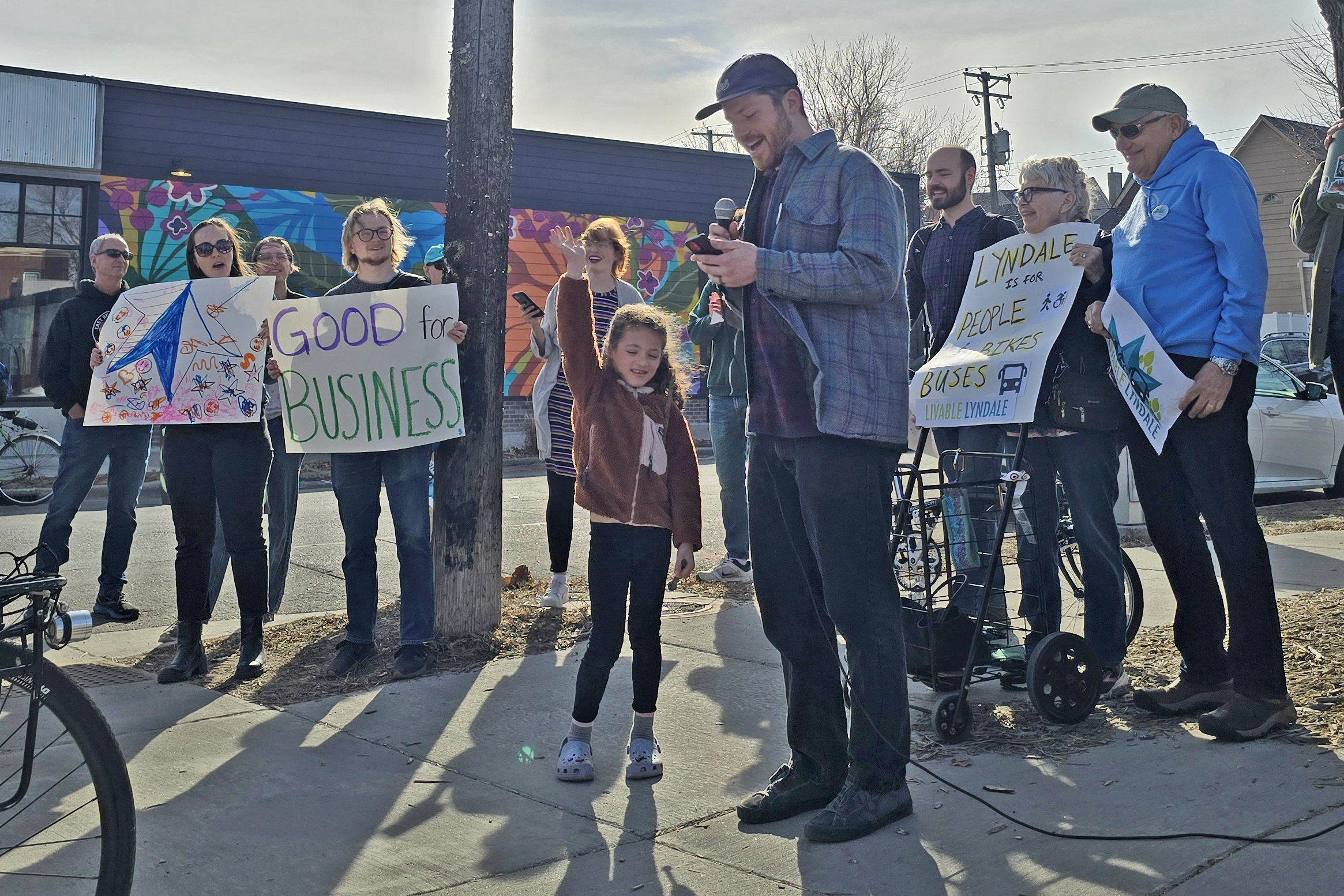 Addressing rally participants, Phil Schwartz, with his daughter Holly, shares how past improvements to Lyndale Avenue made it more pleasant for his family to visit and travel along Lyndale Avenue 