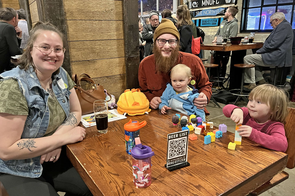 A family with two small children playing with large Legos at a table at the event