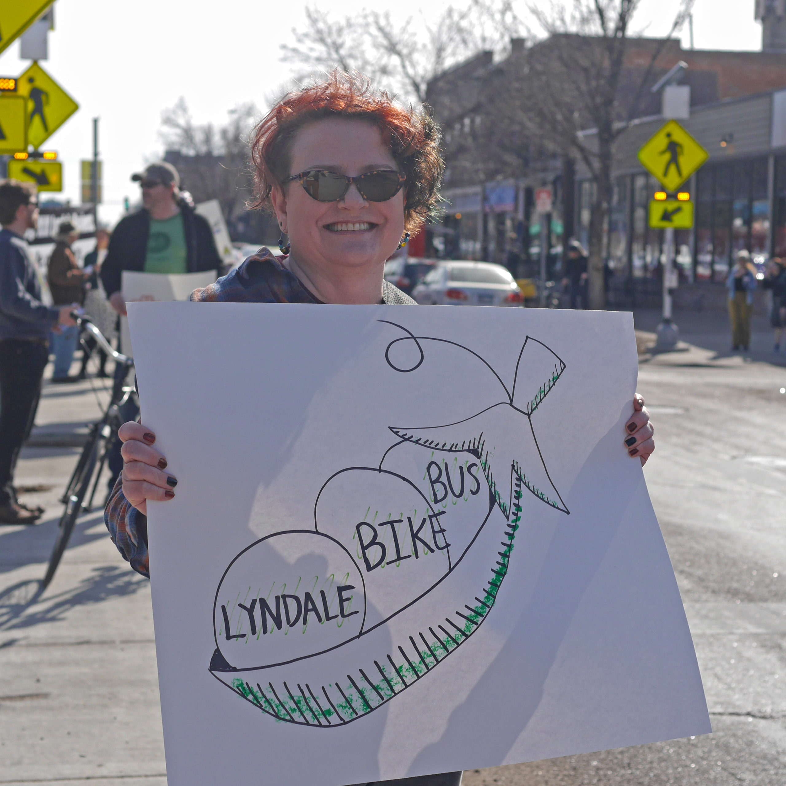 A community member holds a sign supporting biking and busing on Lyndale at the Livable Lyndale rally in Minneapolis. 
