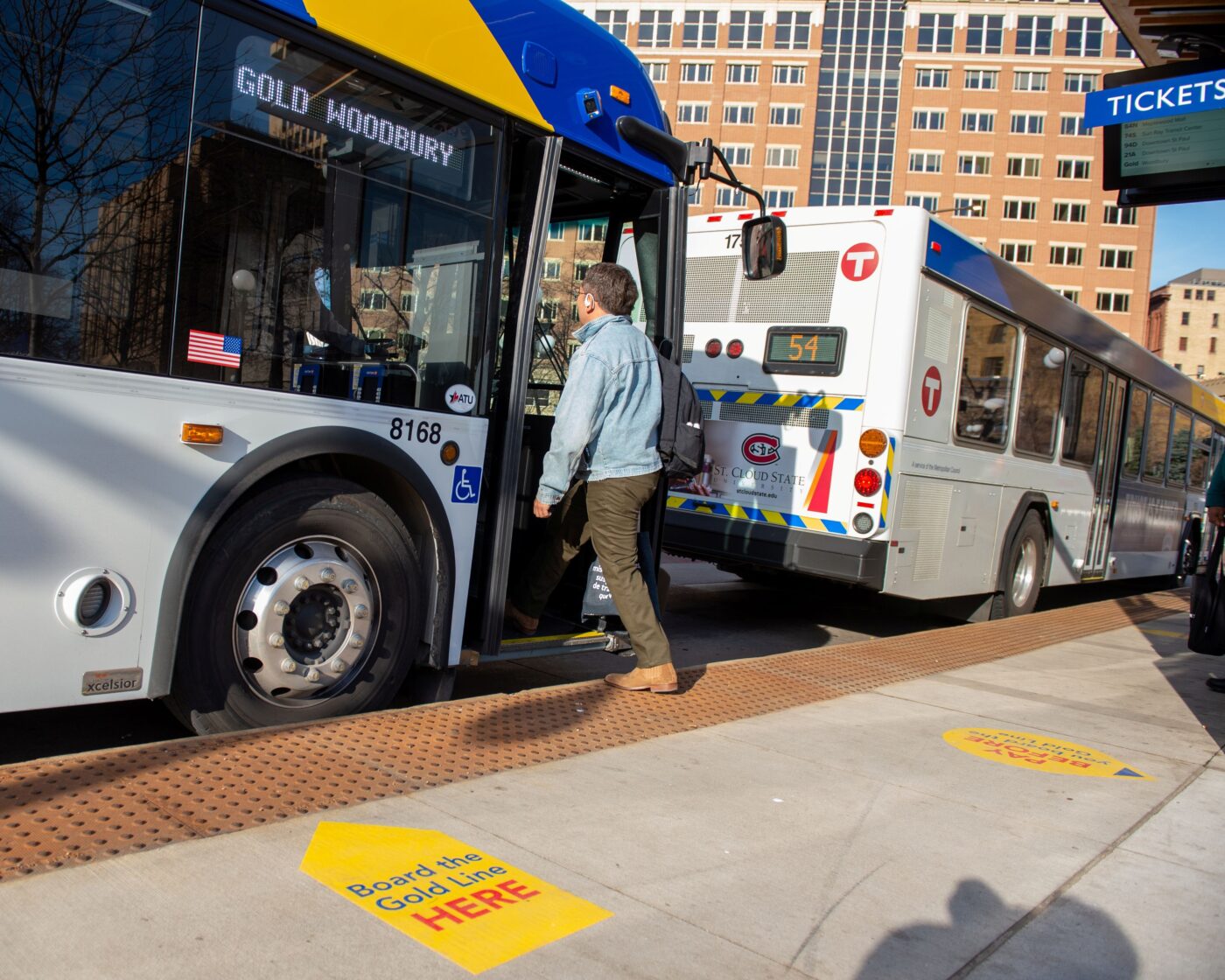 A rider steps onto the Gold Line bus in Rice Park in Saint Paul.