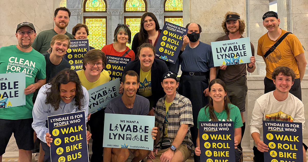 A group of people hold Livable Lyndale signs at the Minneapolis City Hall